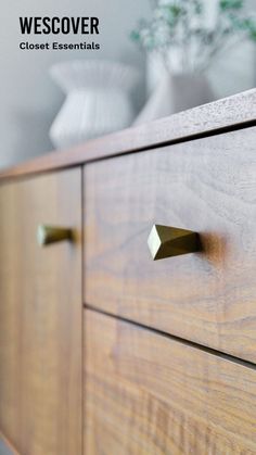 a close up of a wooden dresser with brass handles