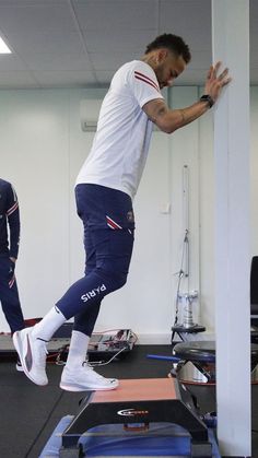 a man standing on top of a treadmill while another man watches from the other side