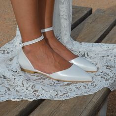 a close up of a person's feet wearing white shoes on a wooden bench