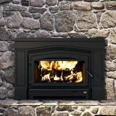 a wood burning stove in a stone fireplace