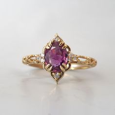 Introducing our captivating Cairo Starry Night Purple Sapphire Ring, a mesmerizing blend of timeless elegance and cultural inspiration. This exquisite ring features a captivating oval bi-color purple sapphire center stone. Crafted with meticulous attention to detail, the band of this ring showcases intricate stars, reminiscent of the stunning architectural motifs found in the bustling streets of Cairo. The oval purple sapphire, set in a secure and stylish double claw prong setting, radiates a de Purple Gem Ring, Purple Engagement Ring, Purple Wedding Rings, Purple Sapphire Ring, Sapphire Eyes, Nature Inspired Engagement Ring, Fall Rings, Purple Rings, Purple Gems