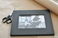 a pair of scissors sitting on top of a table next to a black and white photo