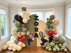 balloon arch with mario and luigi characters on it in the middle of a room filled with balloons