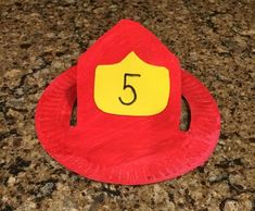 a red paper plate with a yellow number 5 on it sitting on top of a counter