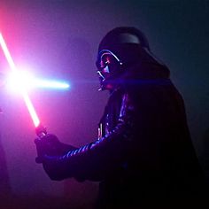 a person in a dark room holding a light saber