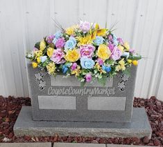 a memorial with flowers in it sitting on the ground