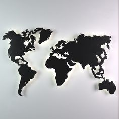 a black and white map of the world on a wall with light coming from it