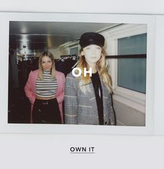 two women standing next to each other in front of a window with the word oh on it