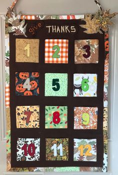 a quilted wall hanging with numbers and leaves on it