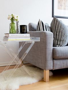 a living room with a gray couch and white rug