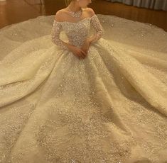 a woman in a wedding dress sitting on the floor with her hands behind her back