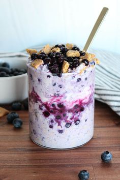 blueberry cheesecake parfait in a glass jar with a spoon on the side