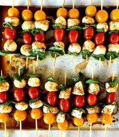 several skewers of meat and vegetables on toothpicks in a baking pan