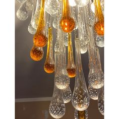 a chandelier made out of glass with yellow and brown bubbles hanging from it