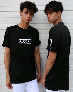 two young men standing next to each other in front of a white wall wearing dobre t - shirts