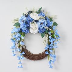 a wreath with blue and white flowers hanging on the wall