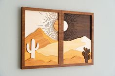 two pieces of wood that have been cut out to look like desert scenes on the wall