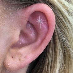 a close up of a person's ear with a small star on it