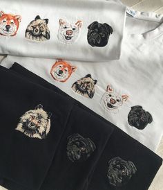 four t - shirts with dogs on them are laying next to each other and one has a dog's face drawn on it