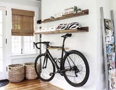 a bike mounted to the wall in a room with wooden shelves and baskets on it