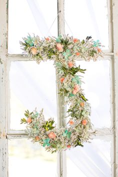 a cross made out of flowers sitting on top of a window sill