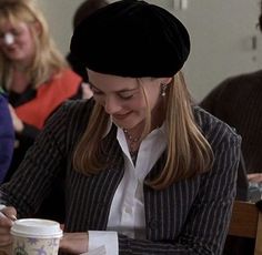 a woman sitting at a table with a coffee cup