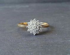 a gold and white diamond ring sitting on top of a table