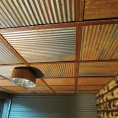 the ceiling is made out of corrugated sheets and has a lamp on top of it