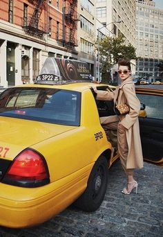 a woman leaning on the back of a taxi cab