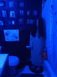 a woman with long hair and makeup standing in a bathroom next to a shower curtain