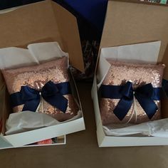 two boxes with pink and blue sequins, one has a bow on it