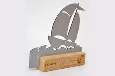 a wooden block with a metal sailboat on it's side and the name port