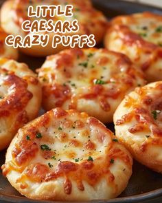 small pizzas sitting on top of a pan covered in cheese and toppings with the words little caesar's crazy puffs