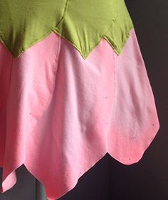 a pink and green dress hanging from a hook