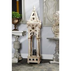 a tall white clock sitting on top of a table