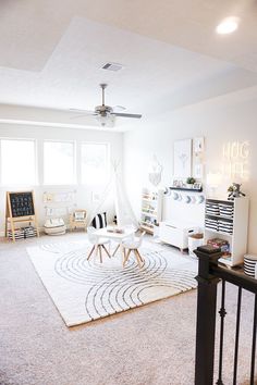 a living room filled with furniture and a white rug on top of a wooden floor