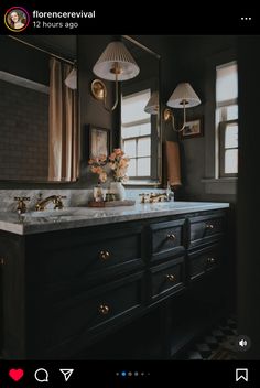 a bathroom vanity with two sinks and mirrors on the wall, along with lights hanging above it