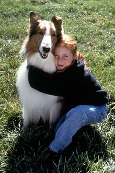 a woman hugging her dog in the grass