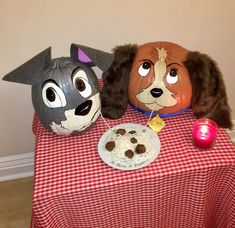 two dog masks sitting on top of a table next to a plate with food in it