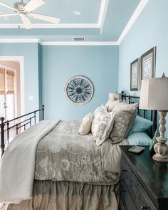 a bedroom with a bed, dresser and ceiling fan