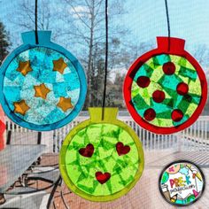 three christmas ornaments hanging from strings on a porch