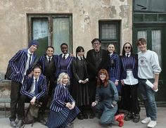 a group of people standing next to each other in front of a building with doors