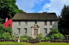 an old house sits in the middle of a lush green yard