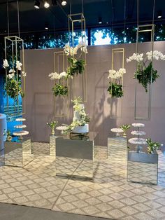 an assortment of vases and flowers on display in a room with white tile flooring