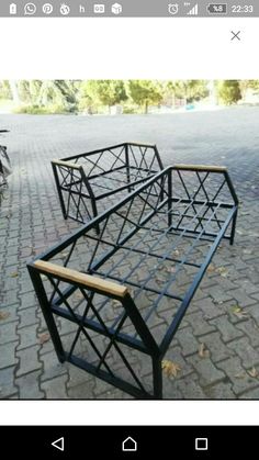 two metal benches sitting on top of a brick road