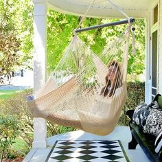 a woman laying in a hammock on the porch