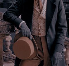 a man in a suit and tie holding a hat