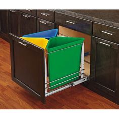 a kitchen with black cabinets and green bins on the bottom shelf, filled with colorful folders