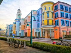 a row of multicolored buildings with bicycles parked on the sidewalk