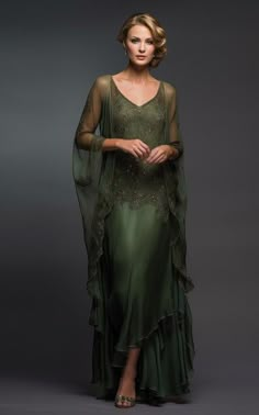 a woman in a green dress with sheer sleeves